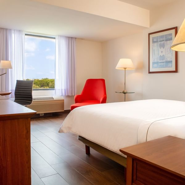Closeup on king bed & lounge in Superior Room at Fiesta Inn