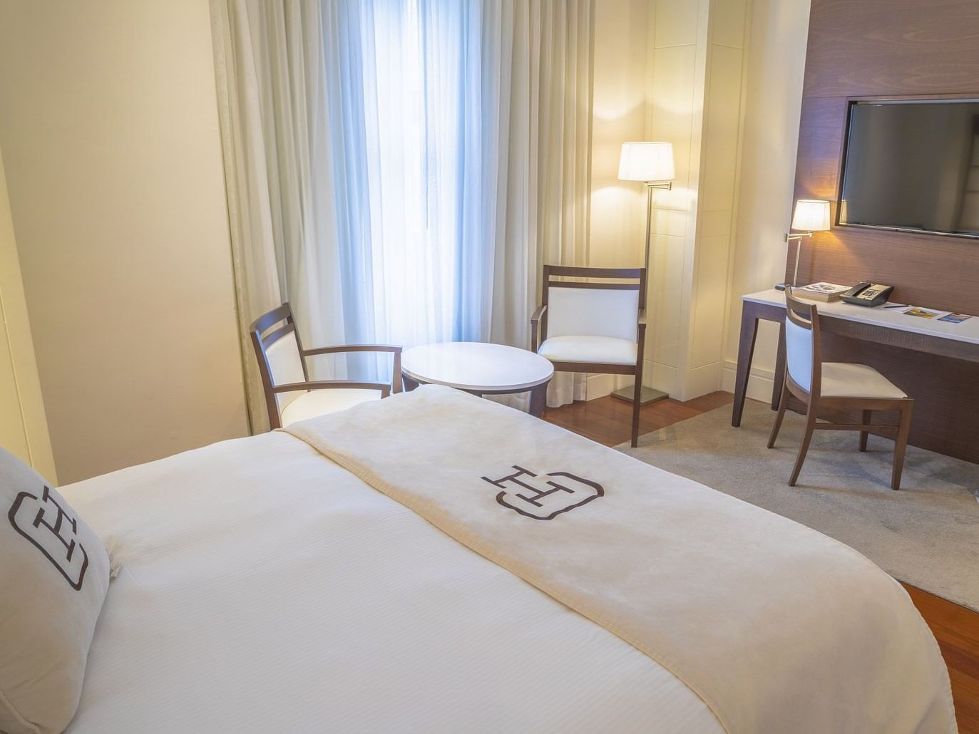 Habitación Deluxe con camas, escritorio y televisor en Central Hotel Panamá Casco Viejo.