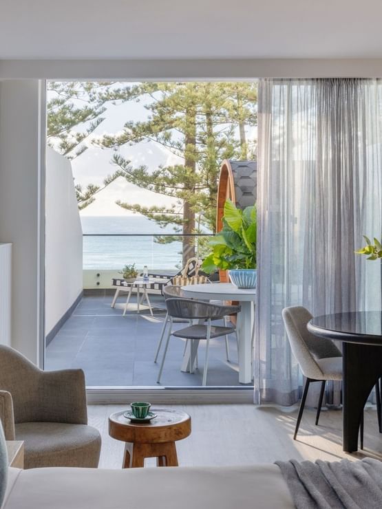 Wellness Suite Twin at Elysium Manly with an armchair by a round table, offering cozy Manly accommodation