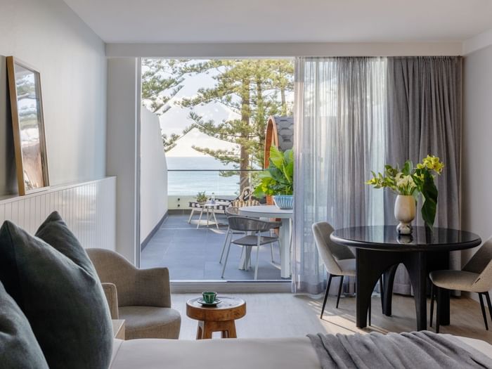 Wellness Suite Twin at Elysium Manly with an armchair by a round table, offering cozy Manly accommodation