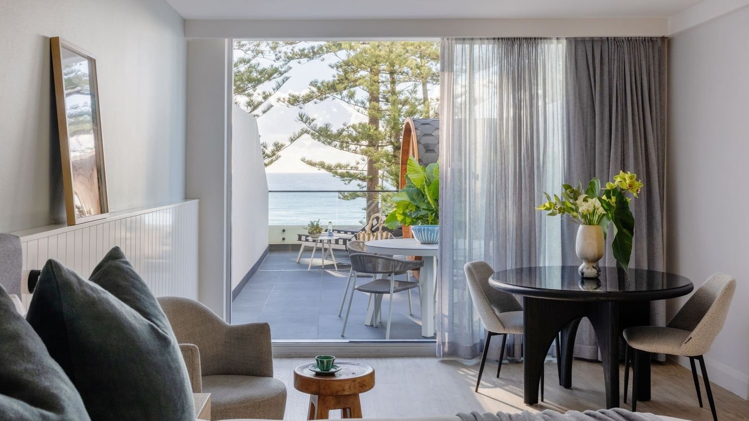 Wellness Suite Twin at Elysium Manly with an armchair by a round table, offering cozy Manly accommodation