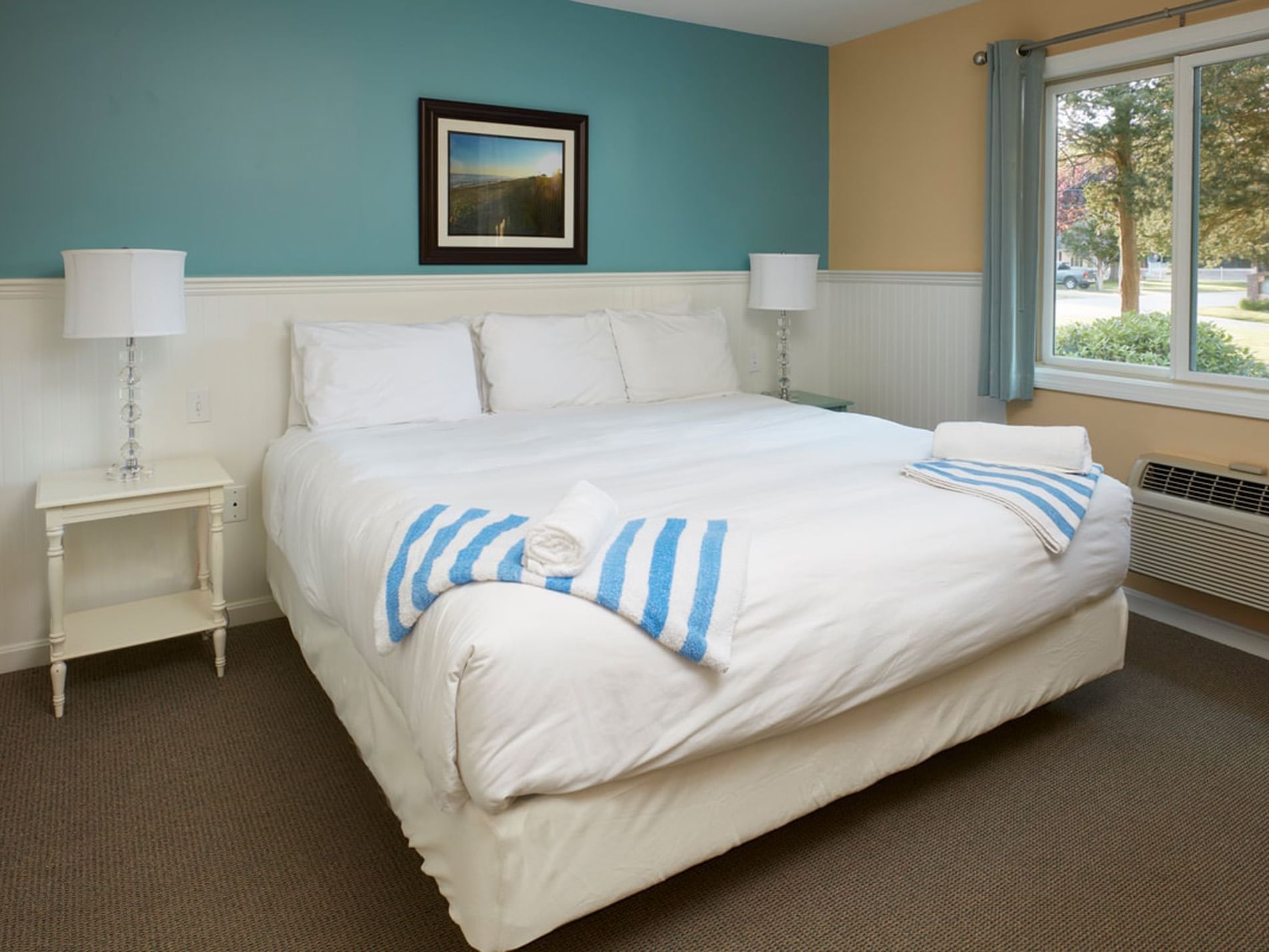Bed with table lamp by the window in Sebe Cottage One Bedroom at Breezeway Boutique Hotel