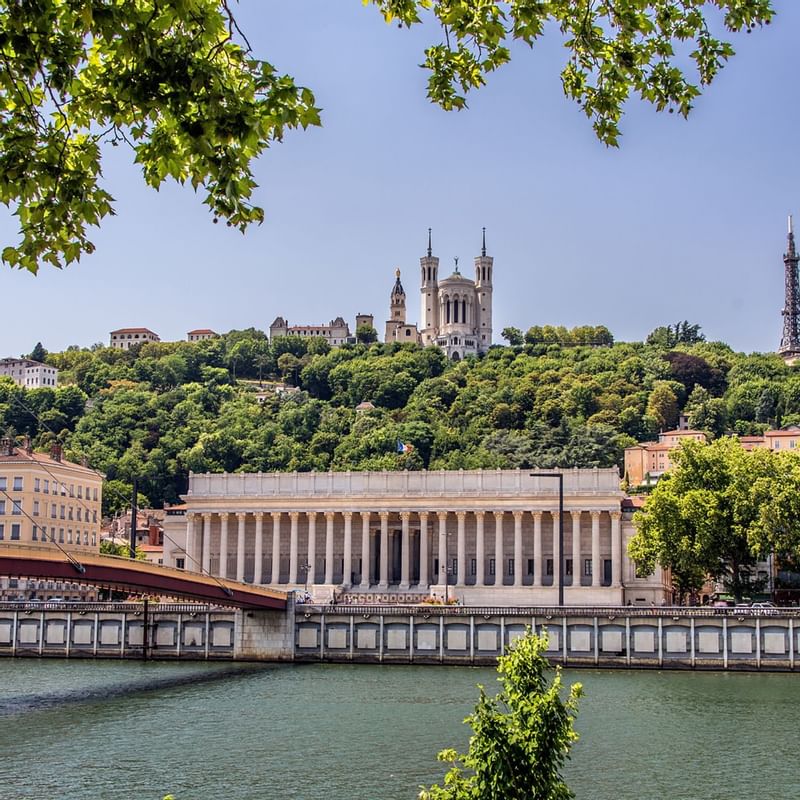 View of the Saône River with a grand building and a bridge near Warwick Hotels and Resorts