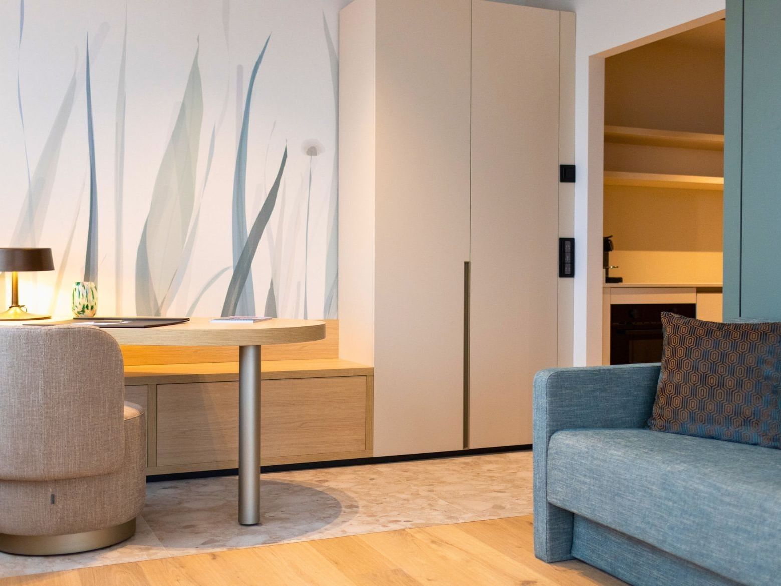 Working desk and seating area in Studio with balcony at Hotel des Innovations with abstract grass mural art