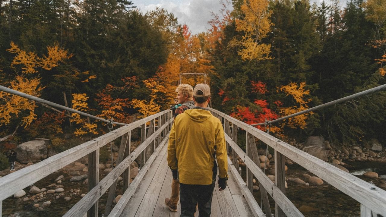Two people walk across a bridge on a larch hike near Canmore