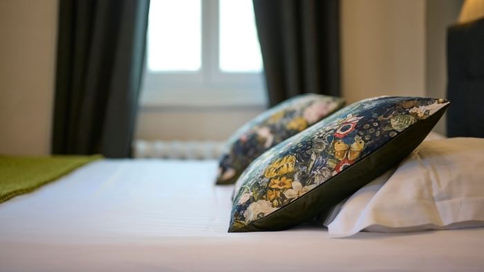 Close-up of floral pillows on a bed at The Originals Hotels