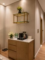 Entry hallway with wooden refreshment cabinet and bedside nightstand in Deluxe Room at Naviti by Warwick Jeddah