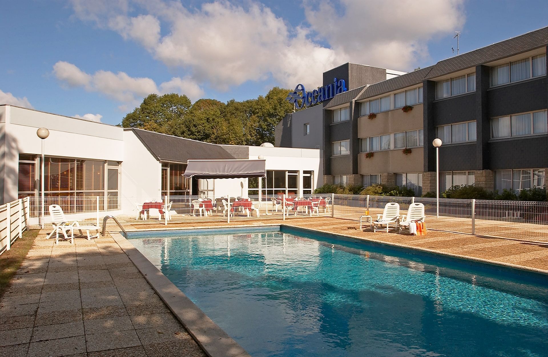 Piscine extérieure avec chaises longues à Oceania Quimper