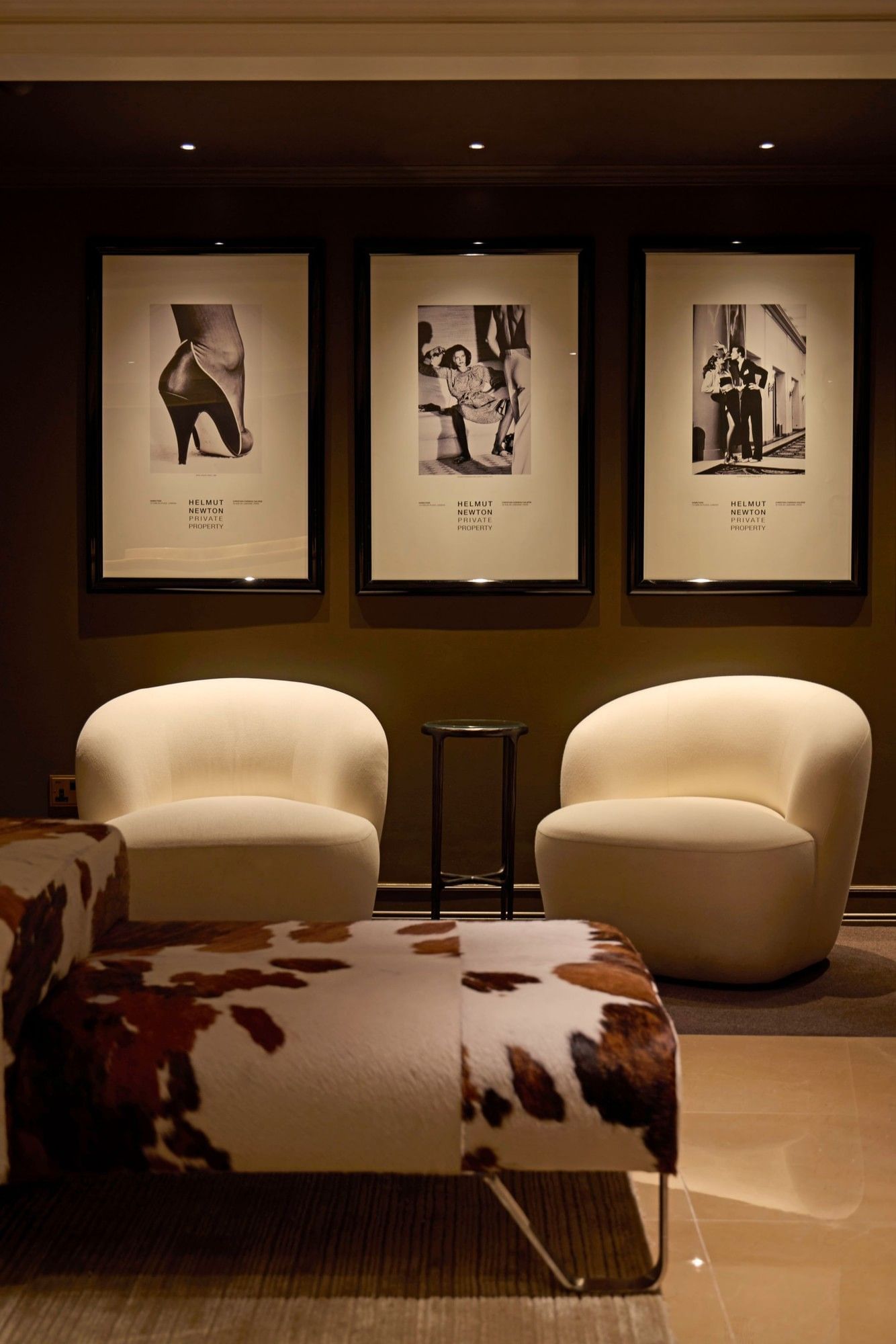 Lounge area with art deco framed prints and elegant furniture at The May Fair Hotel London.