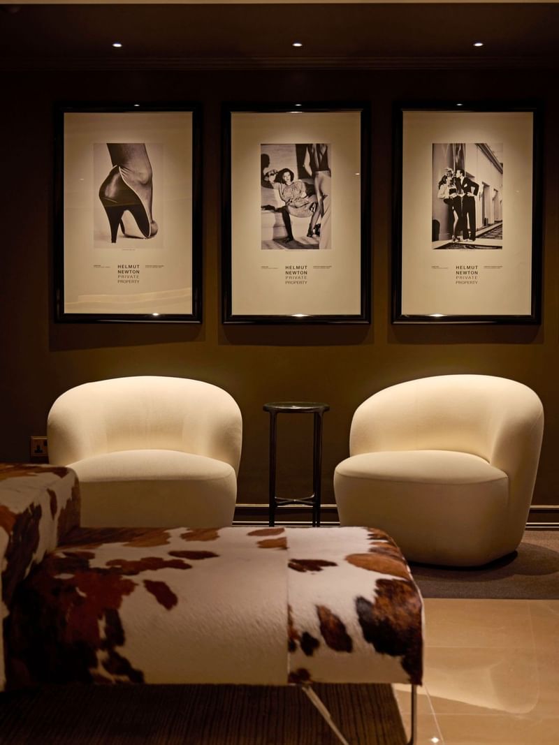 Lounge area with art deco framed prints and elegant furniture at The May Fair Hotel London.