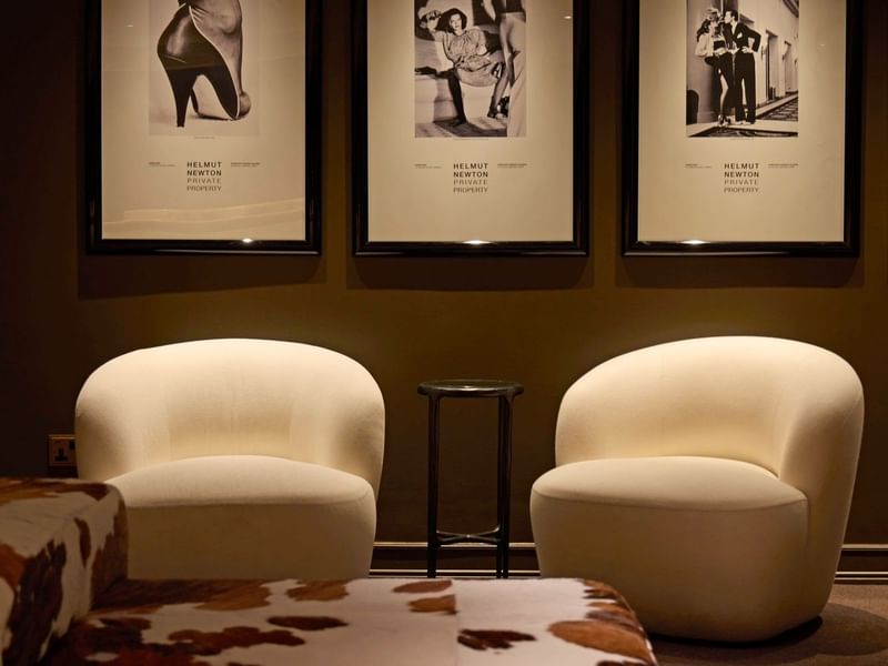 Lounge area with art deco framed prints and elegant furniture at The May Fair Hotel London.