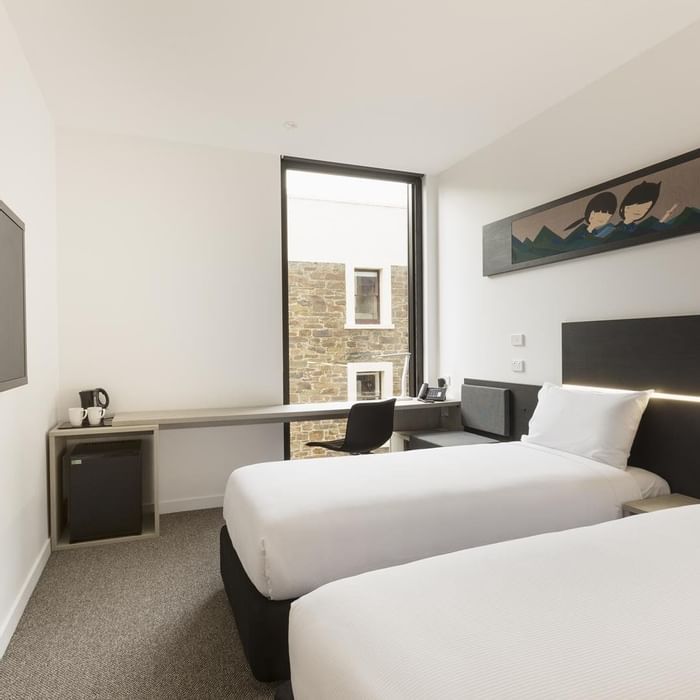 TV facing two beds and workspace by the window in Standard Room Two Single Beds at Ibis Adelaide