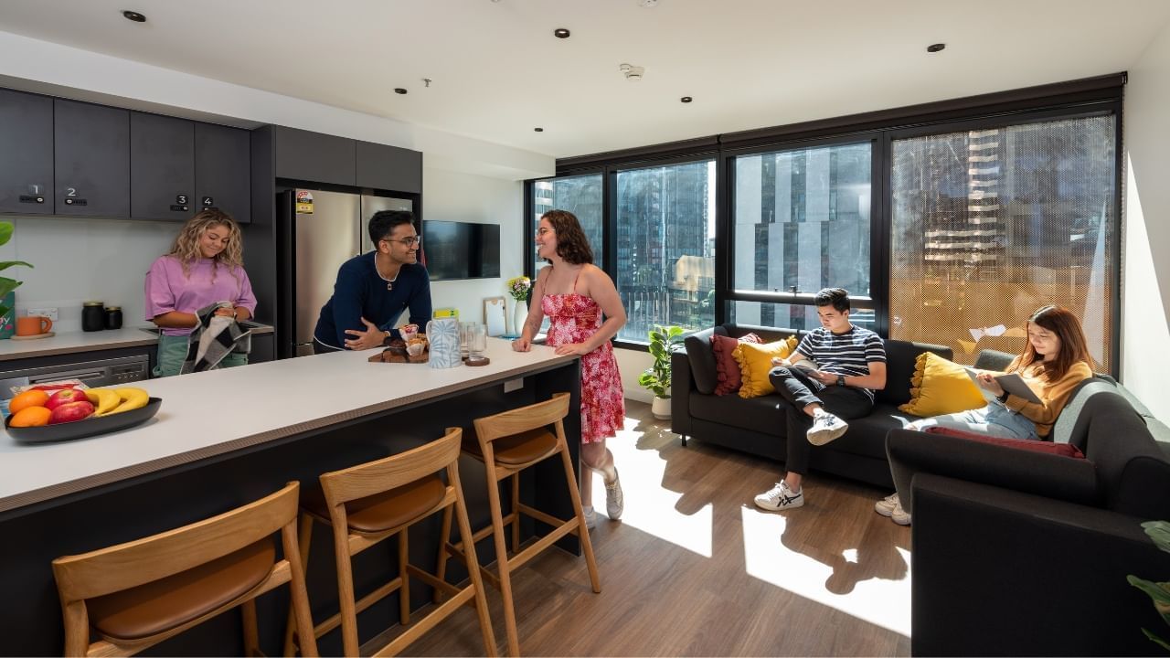 Residents in a modern, living area in shared apartment with large windows and city views.