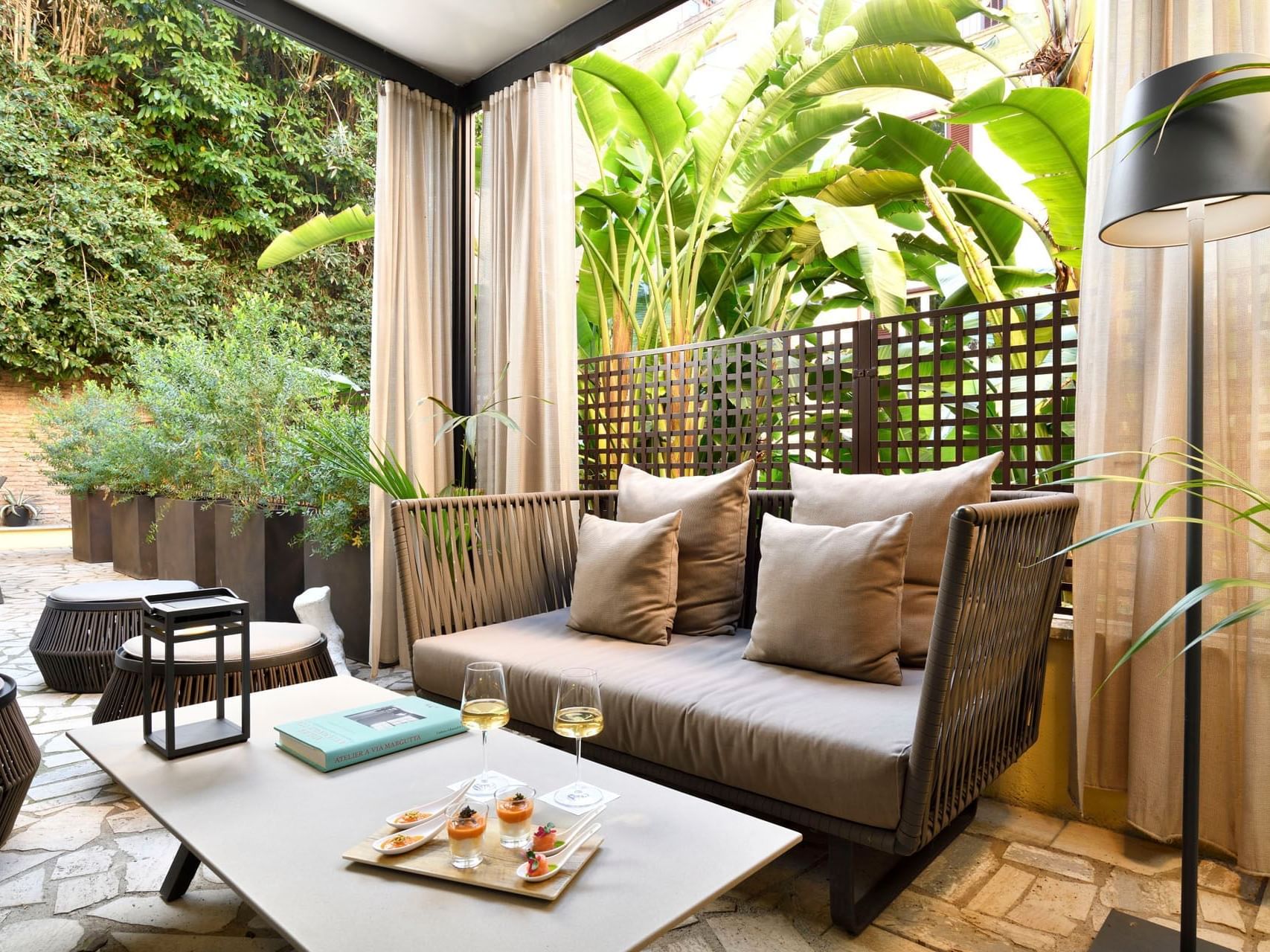 Lounge area with comfy seating and a coffee table with greenery backdrop in Garden Suite at Margutta 19