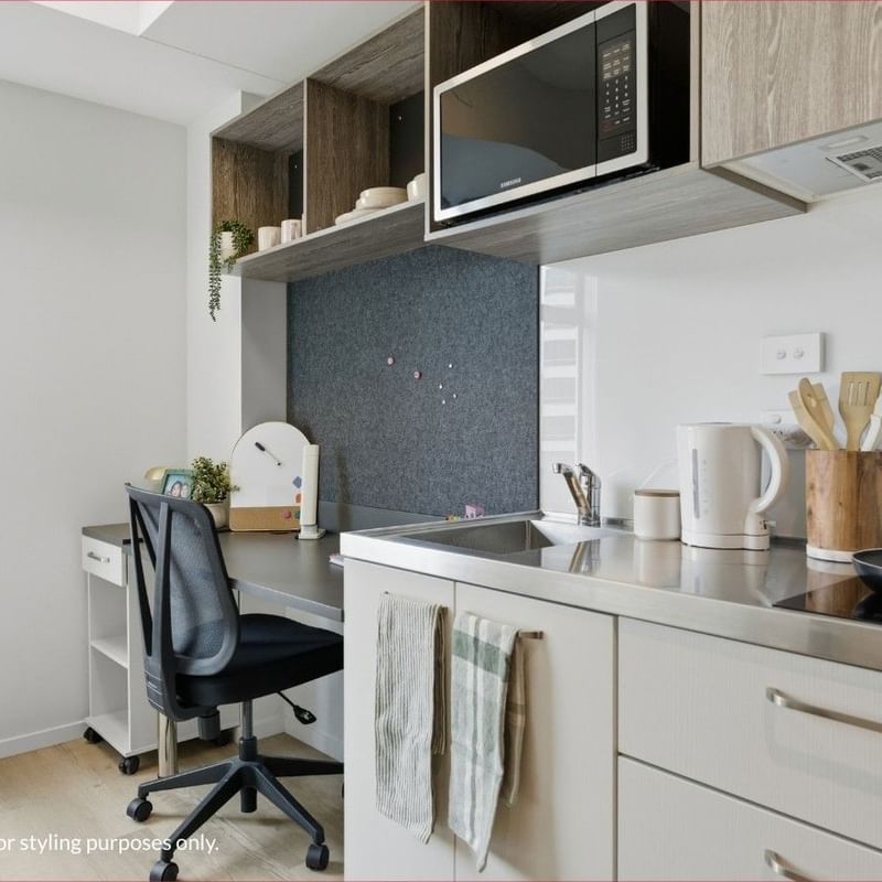 Modern kitchen with microwave, sink, and desk at Mayoral Drive Student Accommodation.