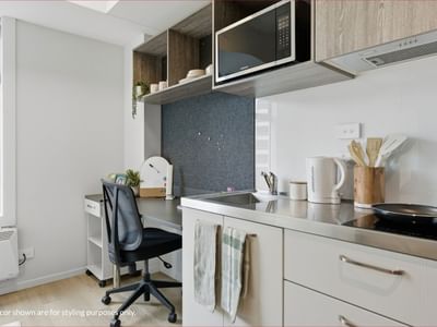 Modern kitchen with microwave, sink, and desk at Mayoral Drive Student Accommodation.