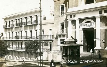 Black and white image of old buildings, with a store named
