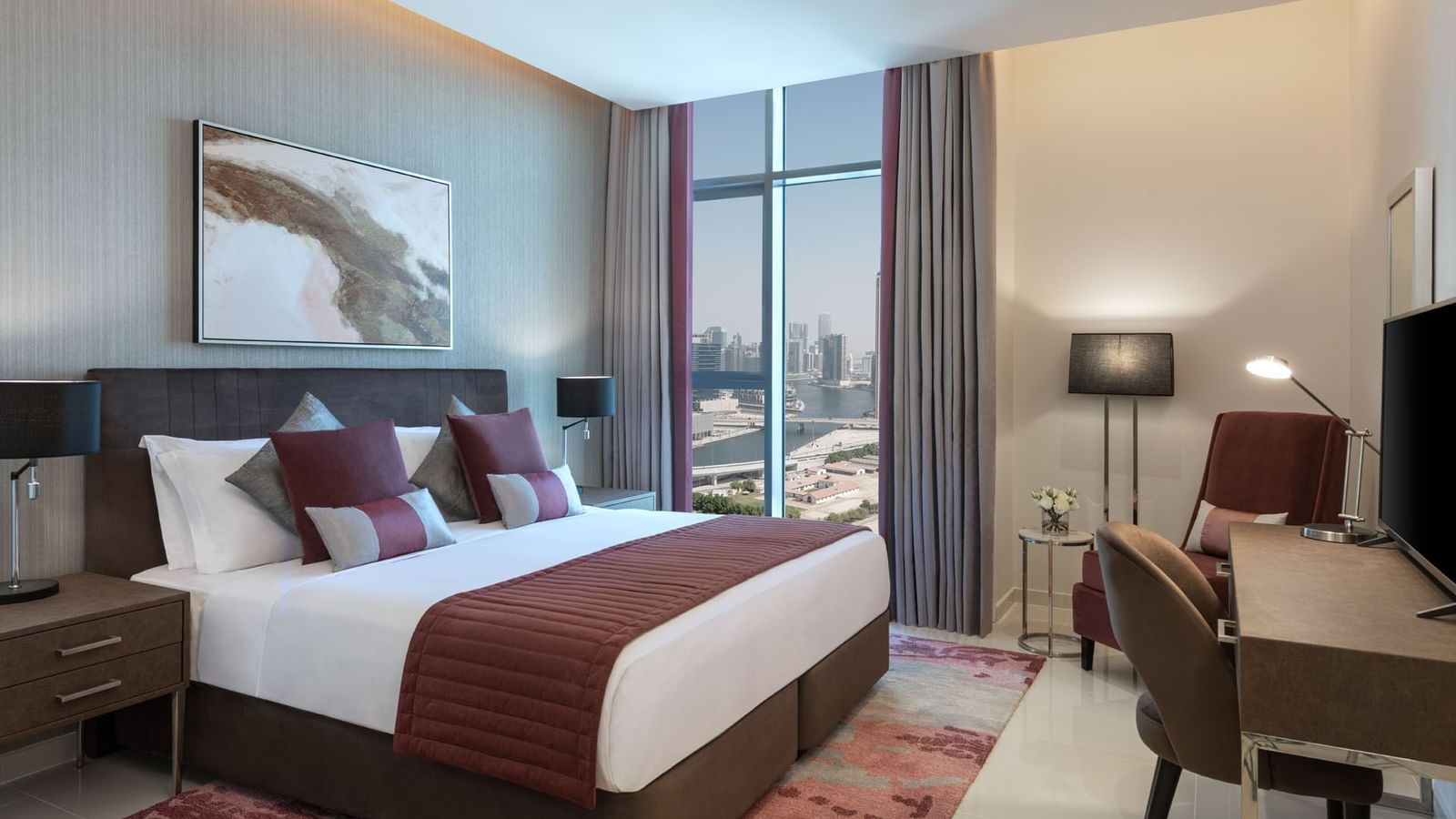 Work desk facing the bed in One Bedroom with a city view at DAMAC Aykon, a luxury apartment in Dubai