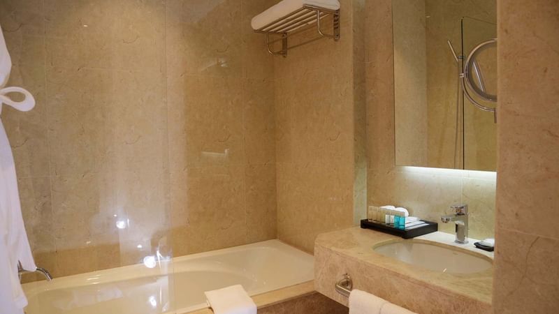 Bathtub & sink with vanity in Executive Room at Warwick Al Khobar