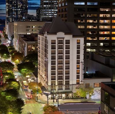 The grand exterior of The Paramount Hotel Seattle illuminated at night, surrounded by the vibrant city