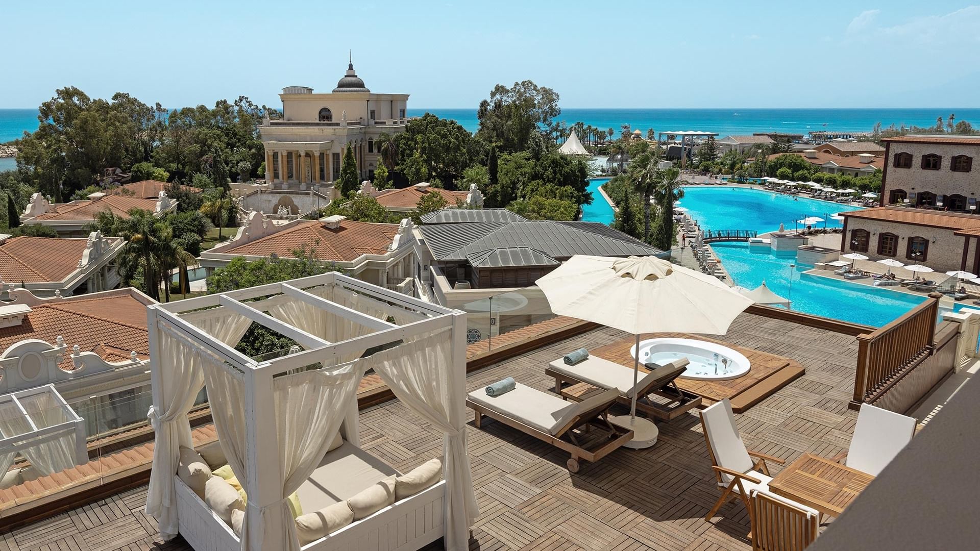 Royal Duplex Suite im Titanic Mardan Palace – Terrasse mit Poolliegen, Sonnenschirm, Whirlpool und Meerblick.