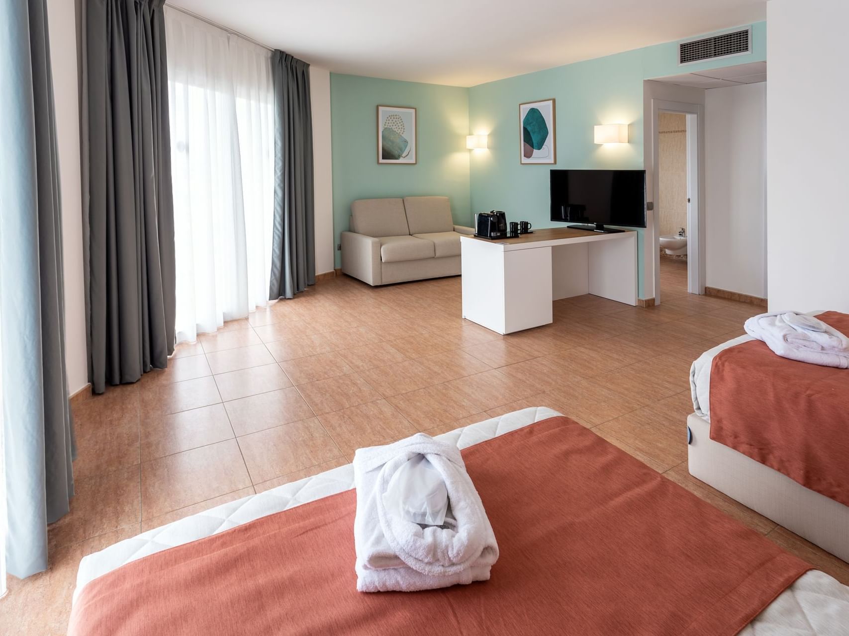 Twin beds, TV and sofa in Junior Suite Rooms at Hotel Piramide Salou