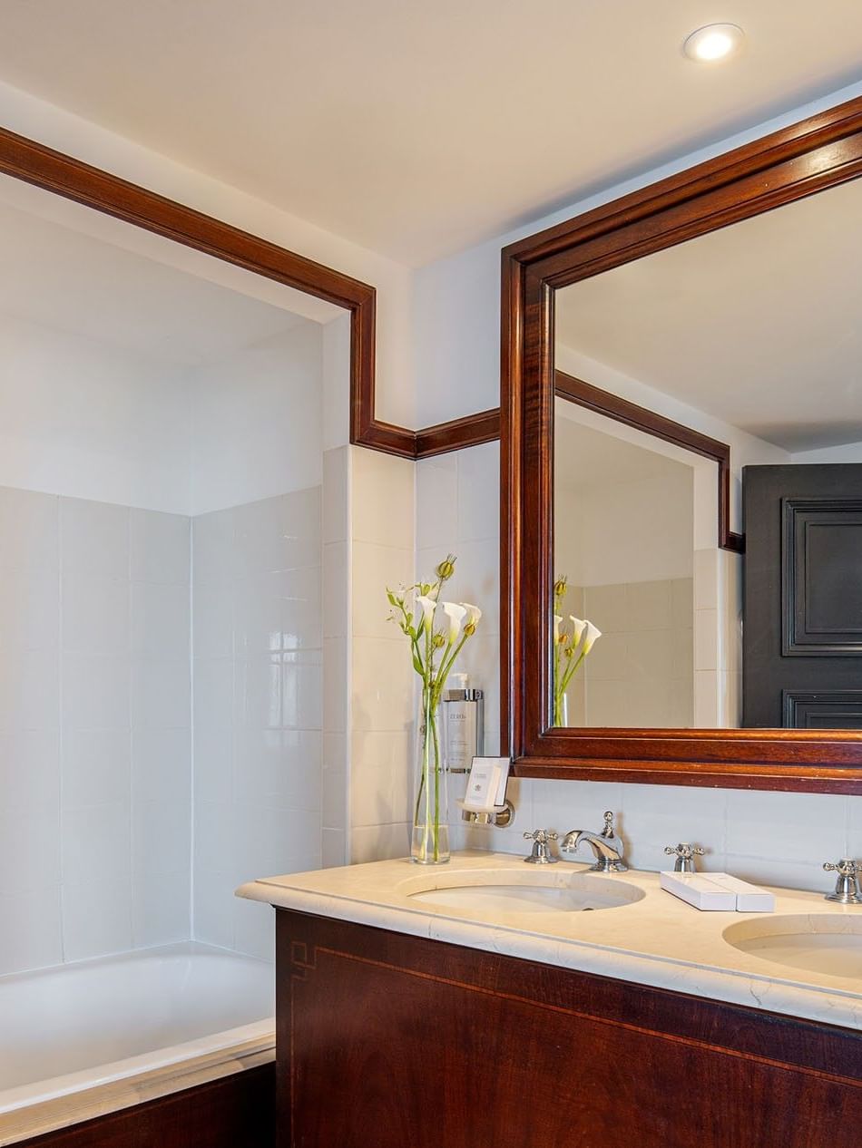 Badkamer van de junior suite met twee wastafels en een bad bij Hotel Barsey by Warwick in Brussel.