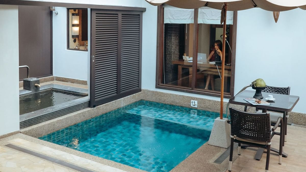 Plunge pool with outdoor seating and a person working inside in Water Villa at The Banjaran Hotsprings Retreat