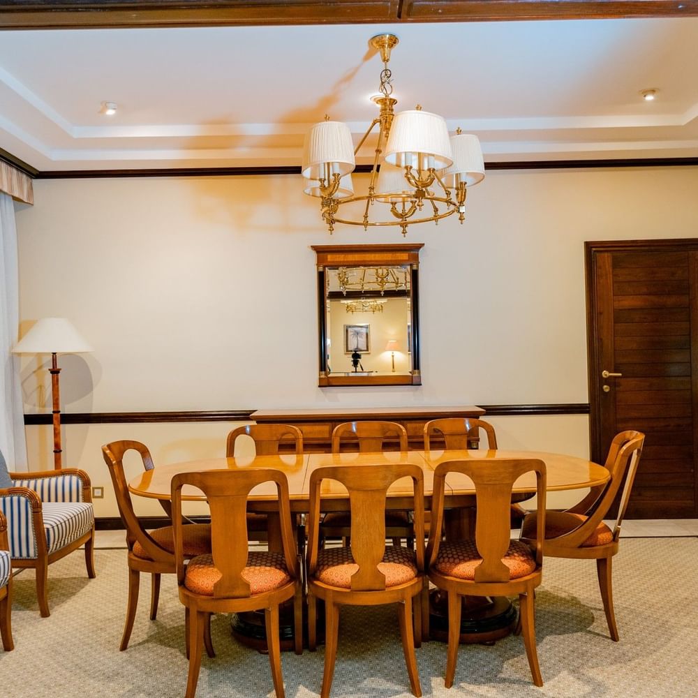 Elegant dining area with round table and chairs under a chandelier at Dar Es Salaam Serena Hotel, Dar es Salaam.