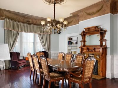 Mid-century wooden furniture featuring a dining table & chandelier at Huntingdon Manor