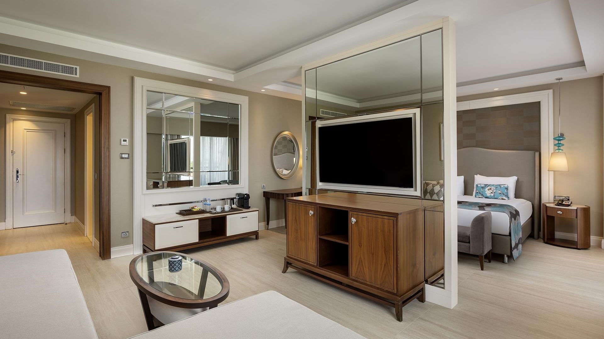 Spacious Deluxe Room with modern decor, large bed, and flat-screen TV at Titanic Deluxe Golf Belek in Antalya.