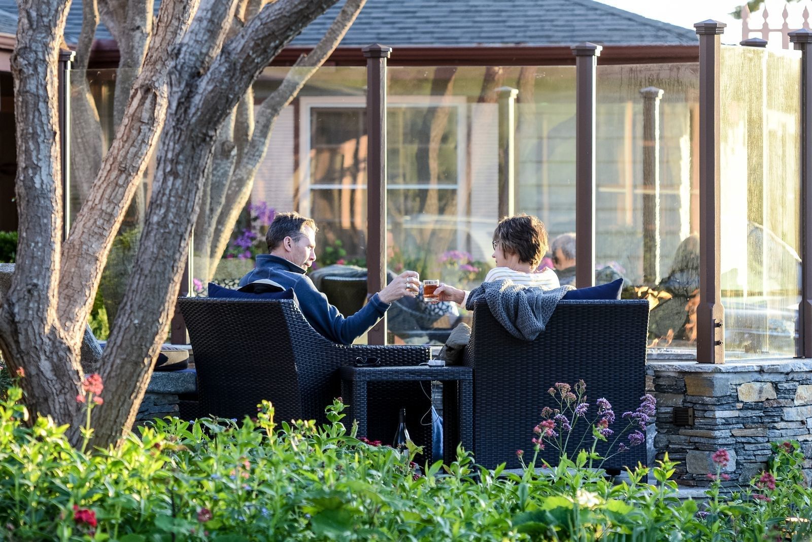 Two people sitting at an outdoor table in a garden