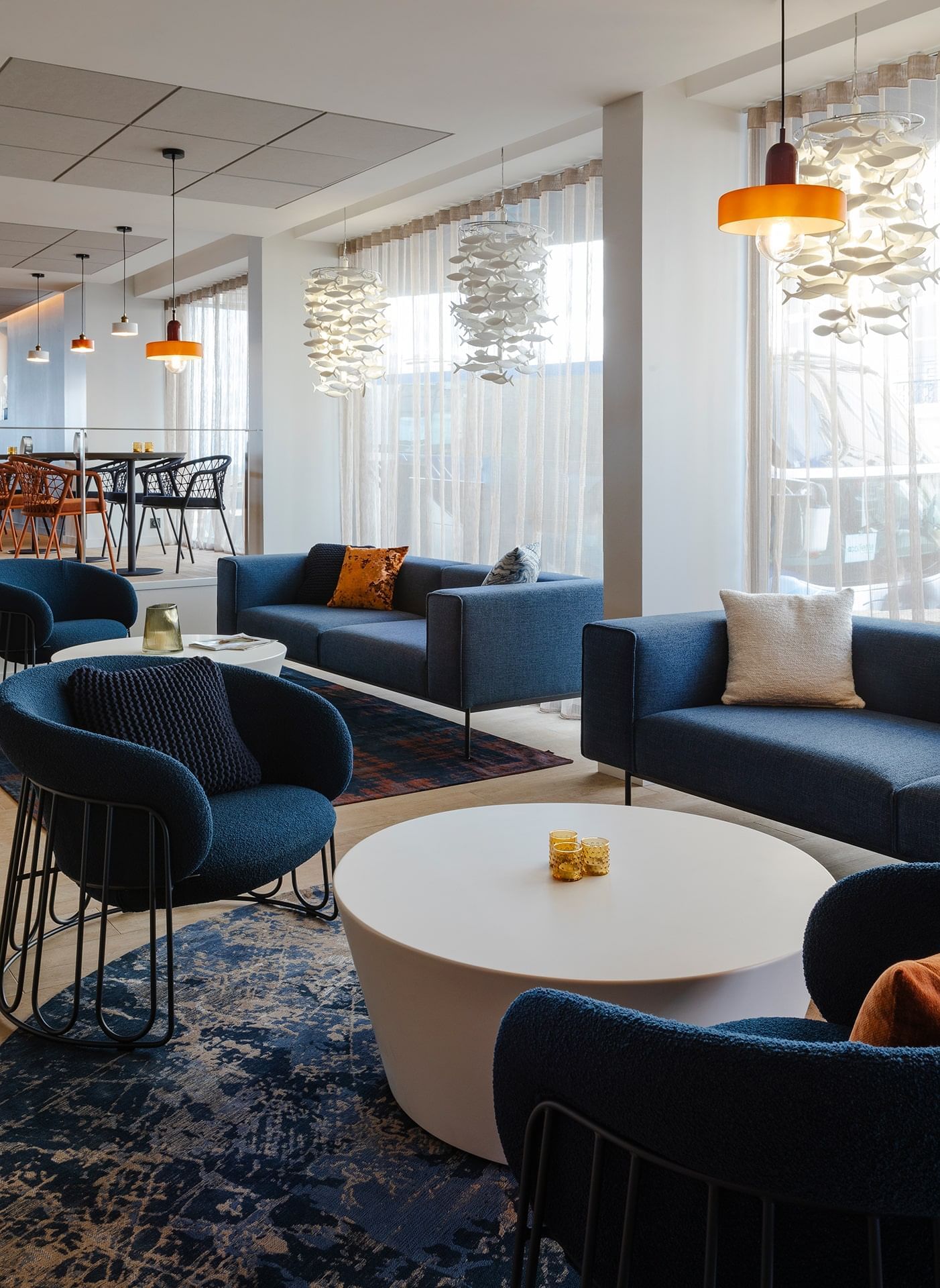 Aménagement de table à manger près d'un canapé bleu dans un restaurant à Oceania Saint-Malo