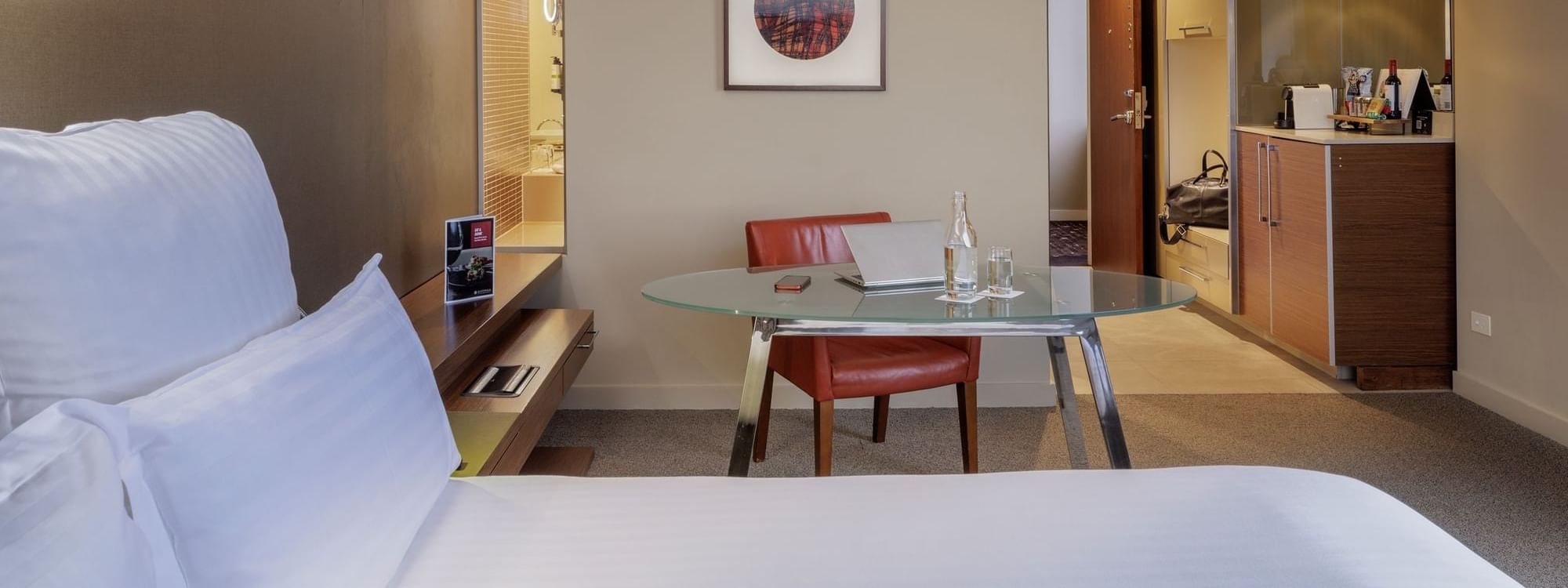 Work desk by the bed and wall-mounted artwork in Pullman Executive Room at Pullman Sydney Olympic Park