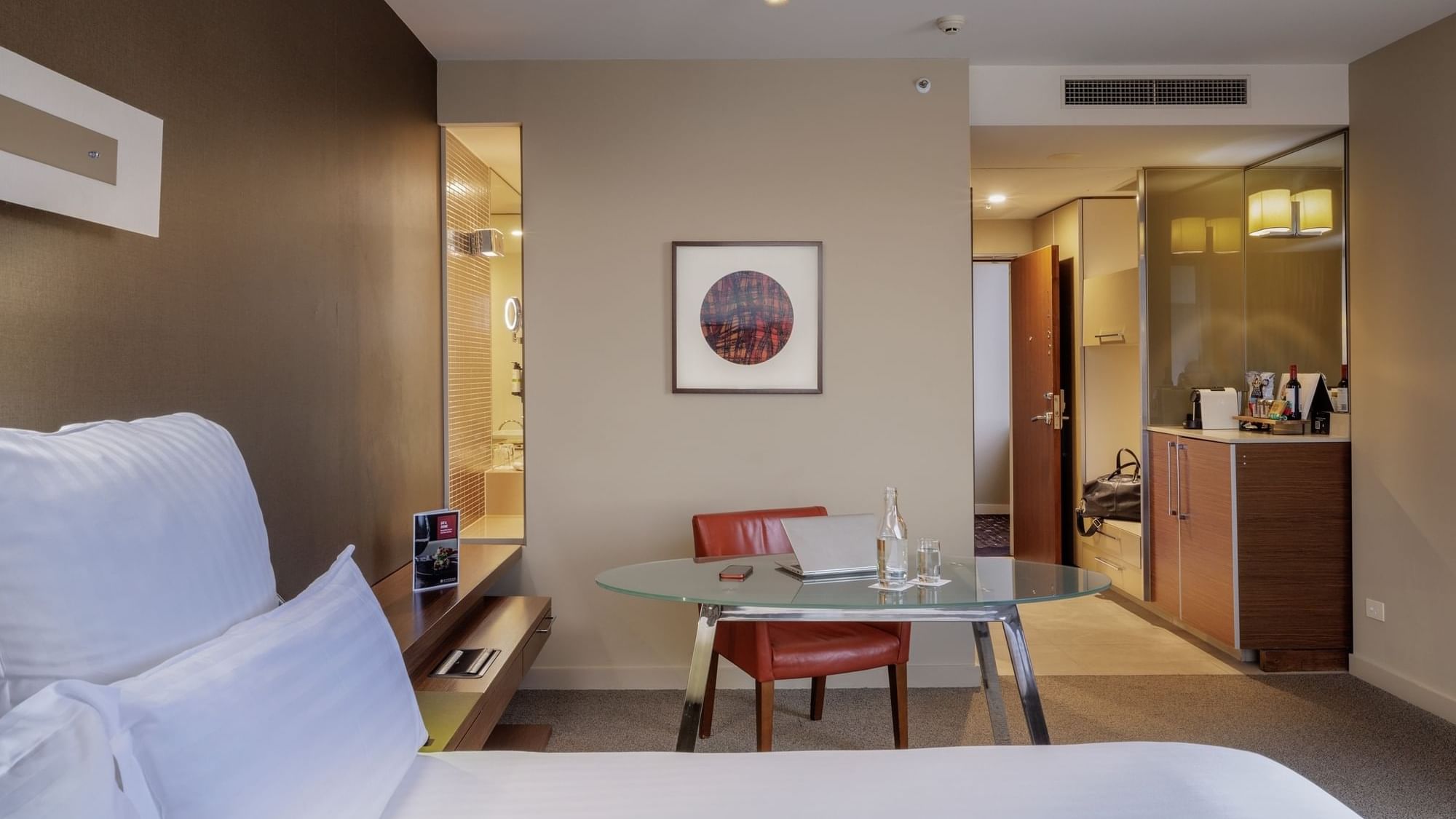 Work desk by the bed and wall-mounted artwork in Pullman Executive Room at Pullman Sydney Olympic Park