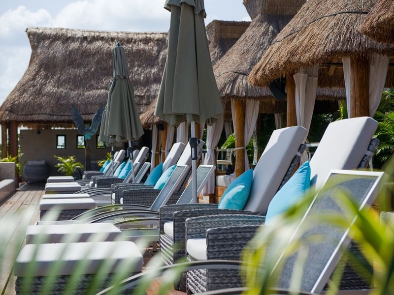 Lounge chairs, cabanas by the pool at Naay Tulum Curamoria