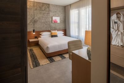 hi-lo hotel room with bed and robe in closet