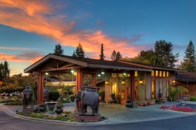 entrance to hotel with elephant decorations and sunset in backgr