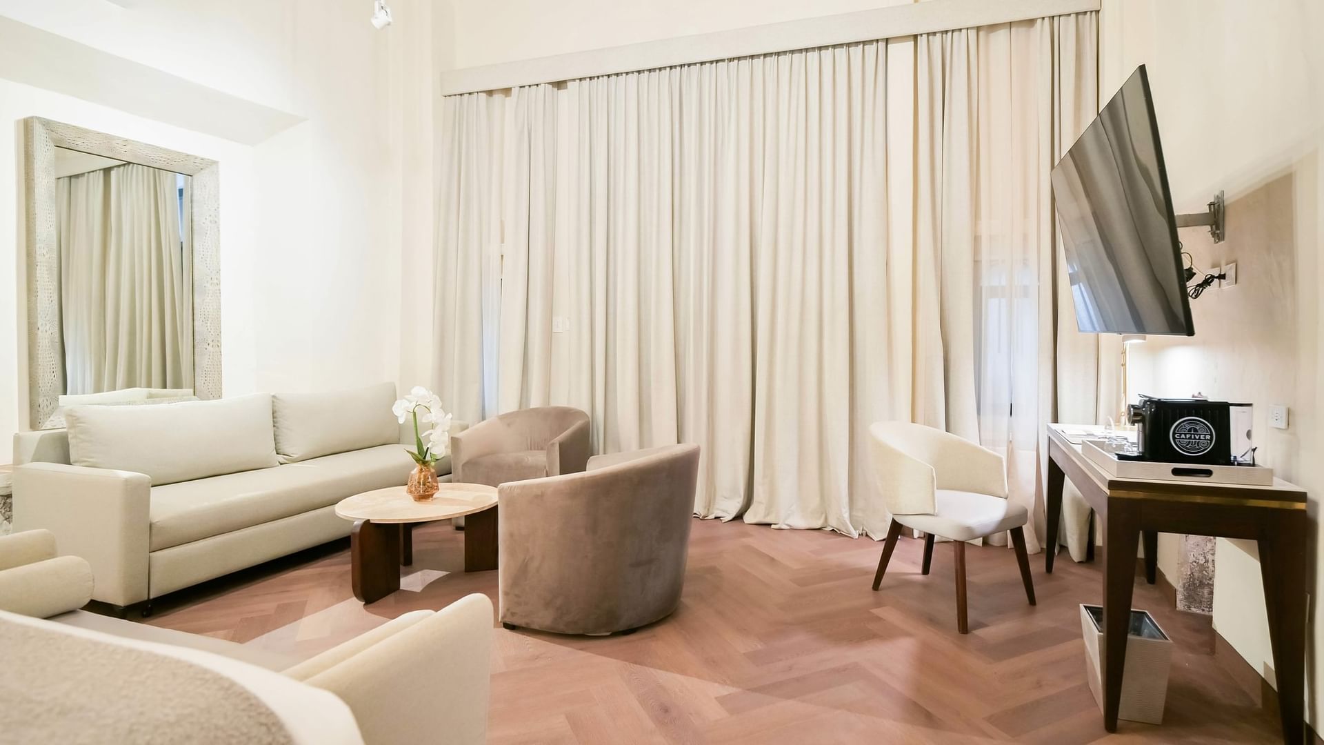 Elegant King Real room with furniture, flat screen TV, and curtains at Quinta Real Puebla in Heroica Puebla de Zaragoza.