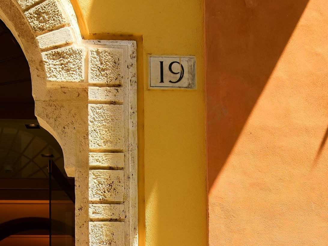 Arched entrance with number 19 plaque on a wall at Margutta 19 