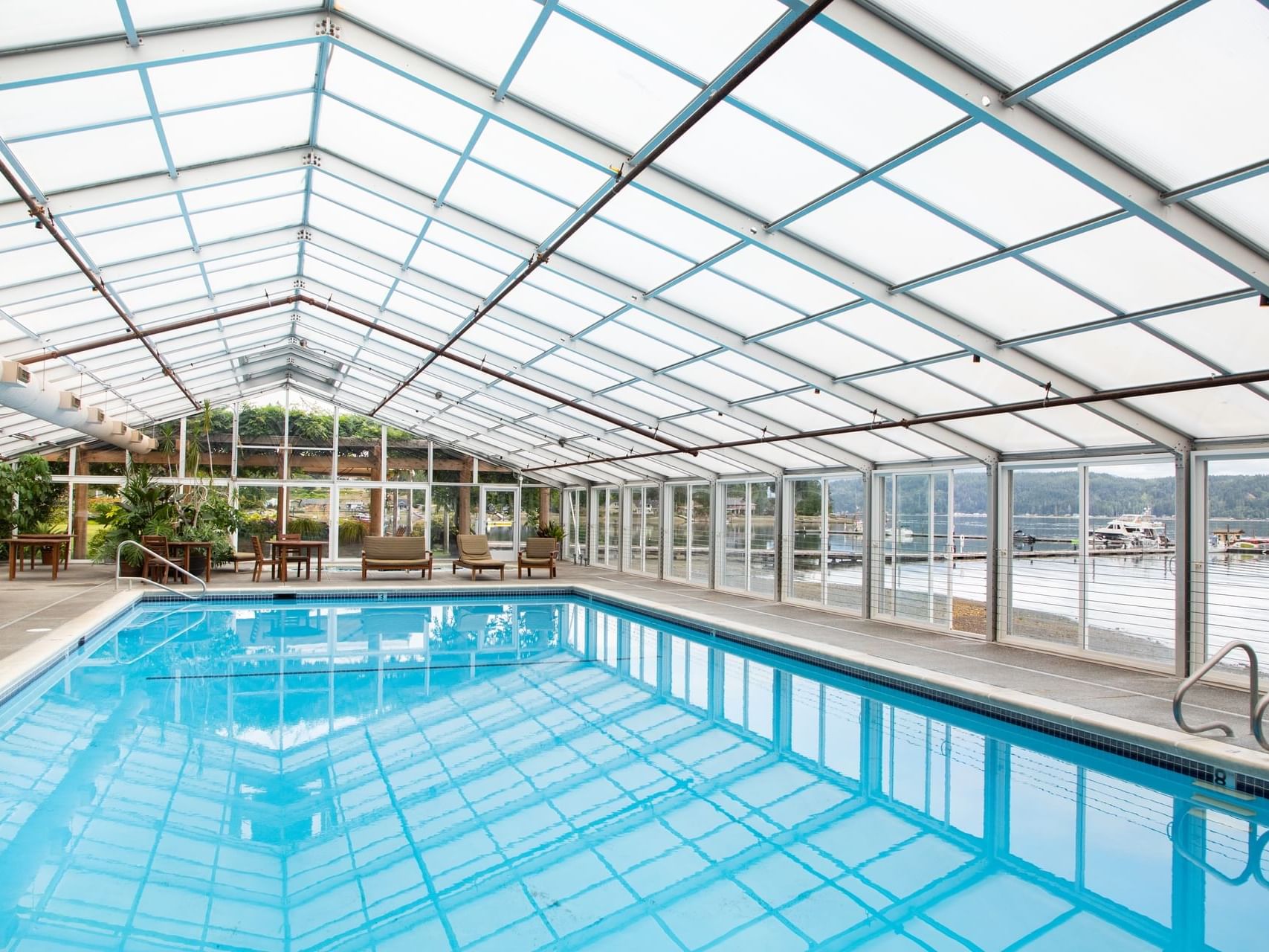 Indoor swimming pool with loungers overlooking the lake at Alderbrook Resort & Spa