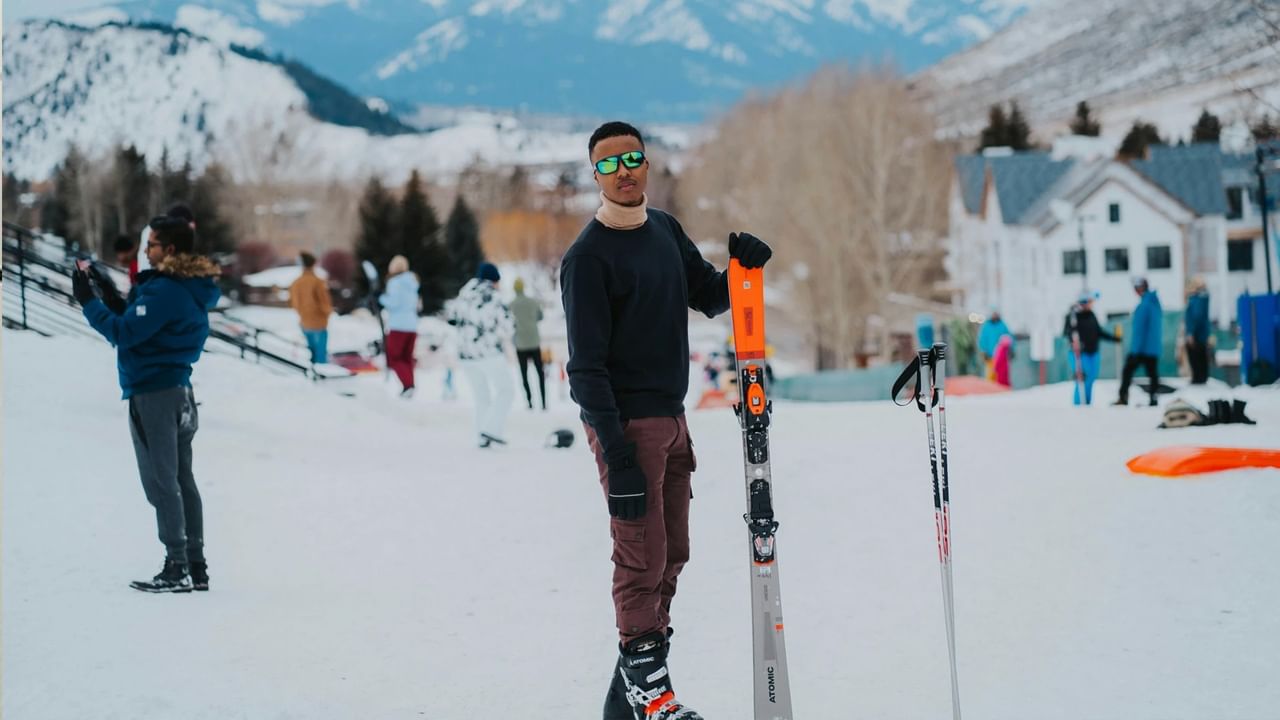 A person holds skis while on a ski resort near Banff.