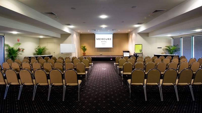 Crystal Room with theatre style chair setup and a projector screen at Mercure Hotel Townsville