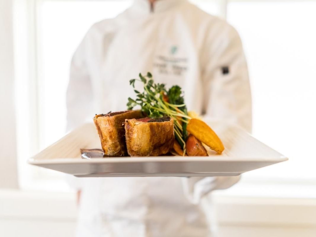 Chef presenting a plate of beef dish in Hardwood's Restaurant at Temple Gardens Hotel & Spa