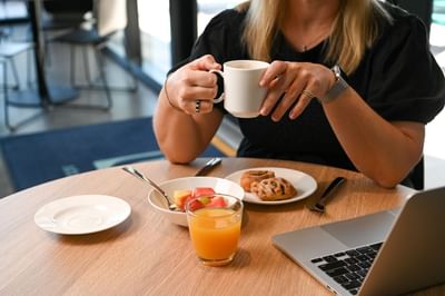 Guest enjoying breakfast while working at Nesuto Curtin Perth