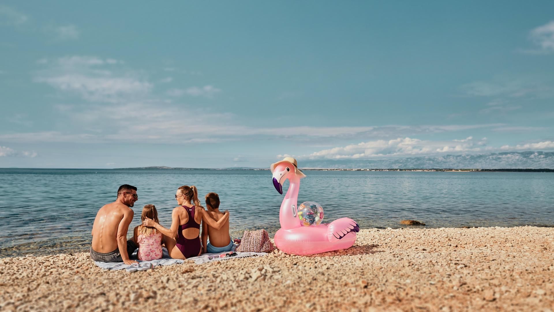 Family on the beach with an inflated toy, Falkensteiner Hotels