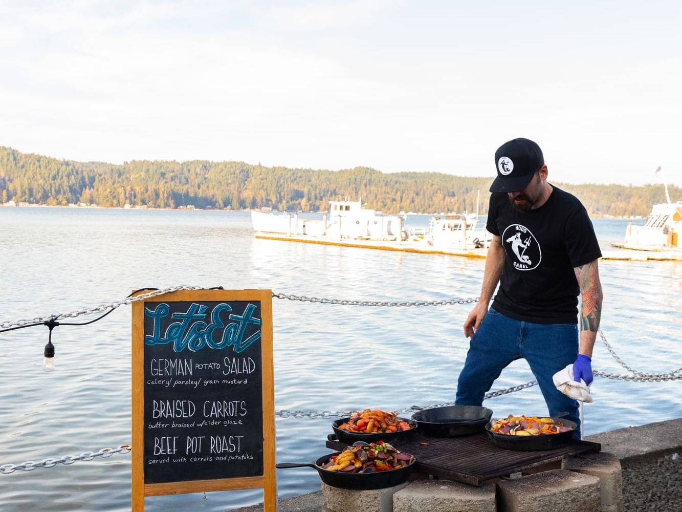 Man grilling food outdoors on a barbecue in Hook & Fork near Alderbrook Resort & Spa