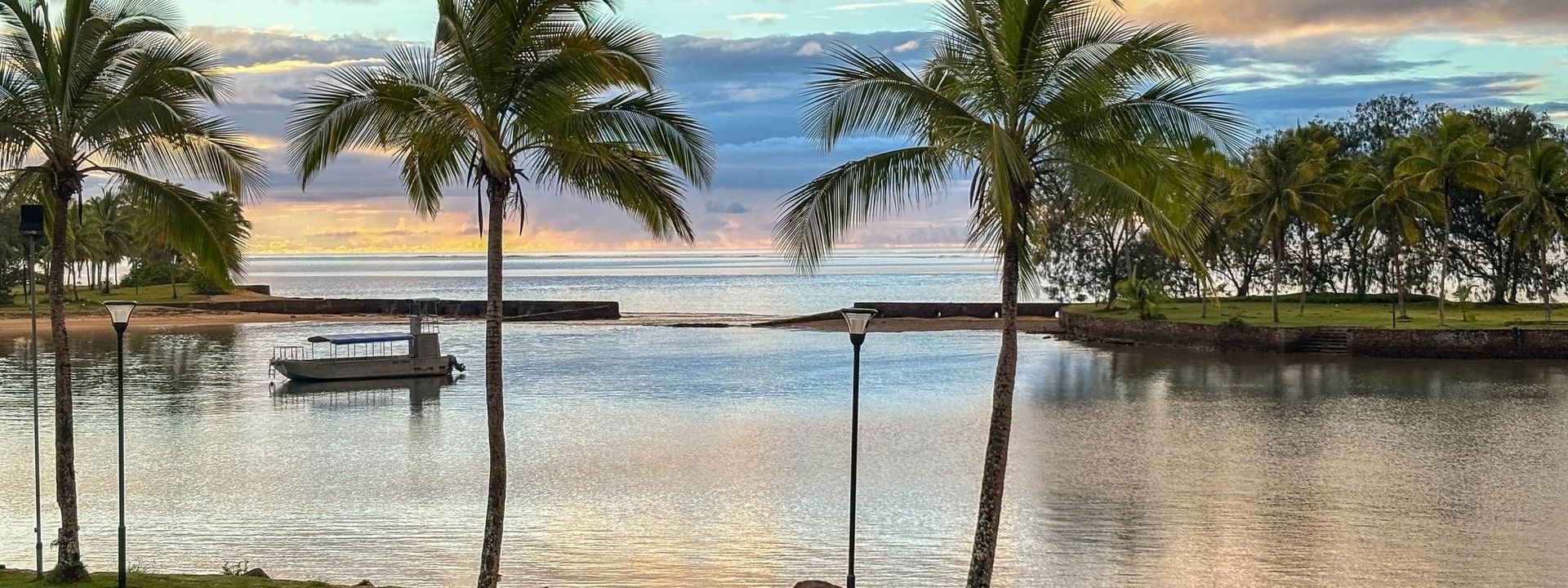 Palm trees and picnic tables near the beach at The Naviti Resort in Korolevu