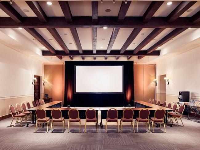 Sala de reuniones Arcos con mesas en forma de U y pantalla gigante en Hacienda del Mar Los Cabos