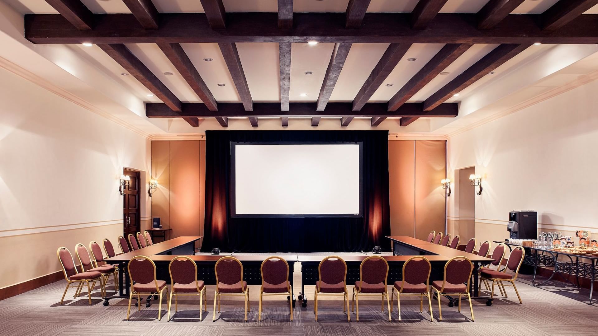 Arcos Meeting room with U-style table arrangements and a large screen at Hacienda del Mar Los Cabos